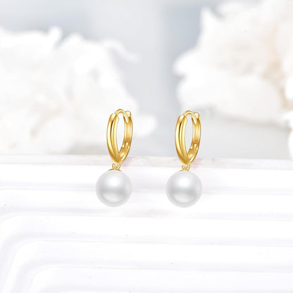Pair of solid 14K gold pearl drop hoop earrings displayed on a pale background.