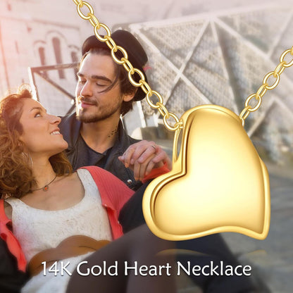 Asymmetric 14K yellow gold heart pendant necklace shown in a lifestyle setting.